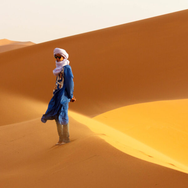Desert man standing on a sand dune.