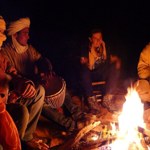 People around the campfire in Merzouga desert during the 5 day desert tour from Marrakech.