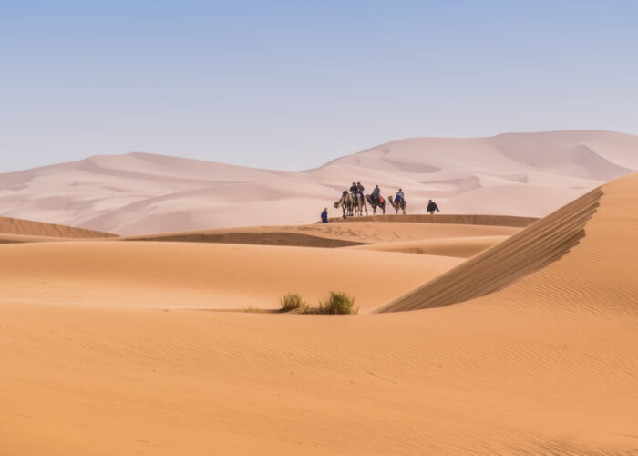 Persone che cavalcano cammelli nel Sahara durante il tour di 5 giorni da Agadir a Merzouga.