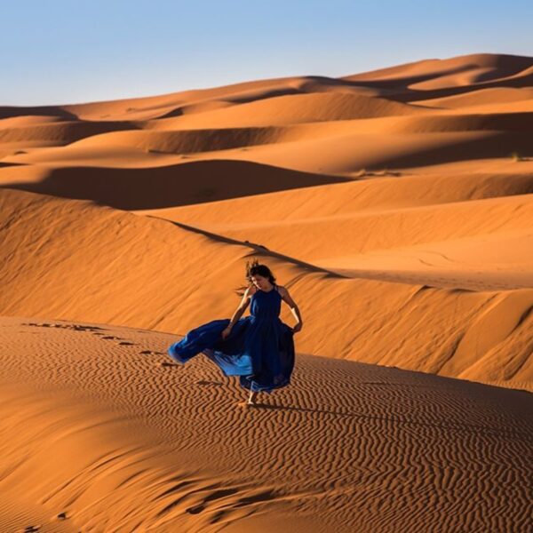 Una donna che cammina nel deserto del Sahara di Merzouga durante il viaggio di 3 giorni da Casablanca a Marrakech.