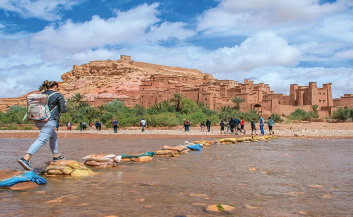 A woman crossing the river to the Kasbah of Ait Benhaddou during the 3-day tour from Ouarzazate to Marrakech.