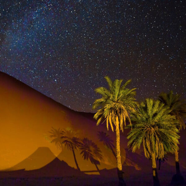 Il deserto del Sahara di Merzouga di notte con un cielo pieno di stelle.