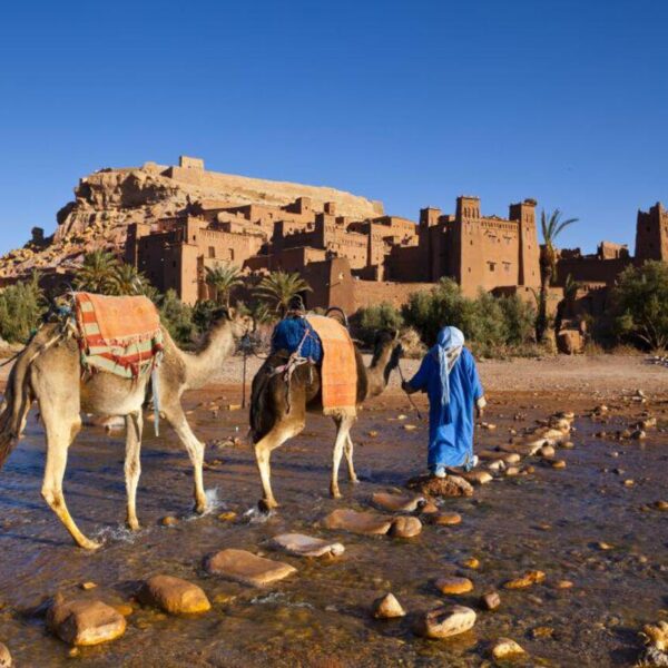 Dos camellos y un camellero cruzan el río Ounila en Ait Benhaddou.