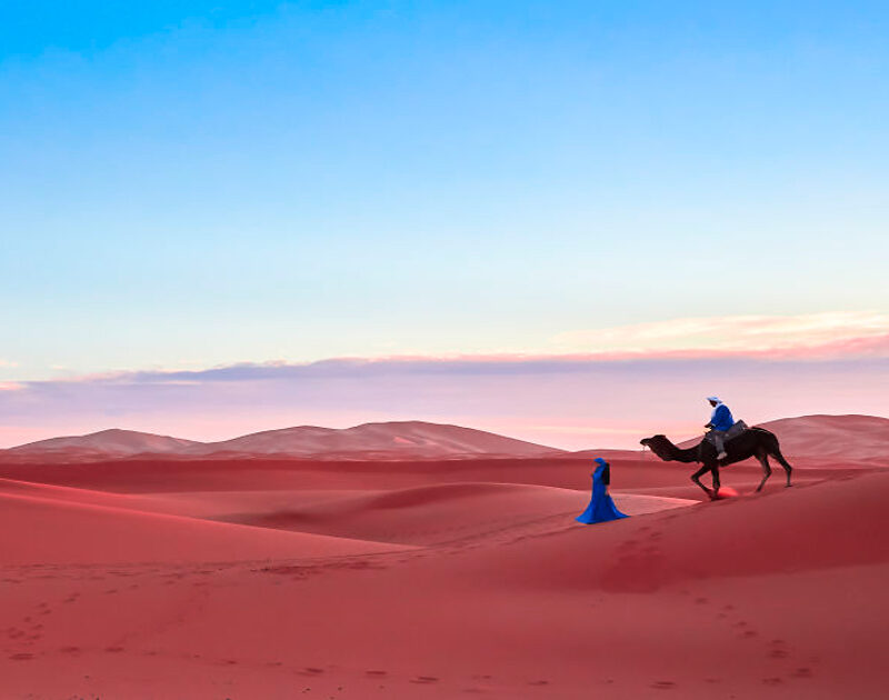 Trekking a dorso di cammello nel deserto marocchino durante il tour di 4 giorni da Fes attraverso la città blu.