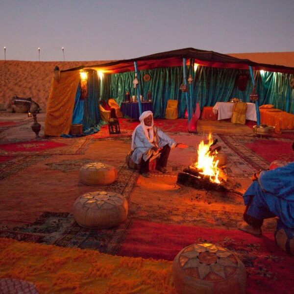 Gente del deserto intorno al fuoco in un accampamento nel deserto di Merzouga, in Marocco.