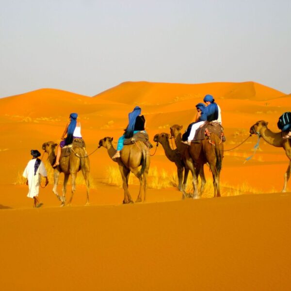 Turistas haciendo senderismo en camello durante el viaje de 12 días a Marruecos desde Tánger.