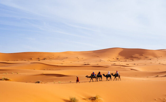 Gente haciendo excursiones en camello en Merzouga durante la excursión de 6 días de Essaouira a Casablanca.