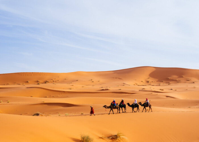 Persone che fanno trekking con i cammelli a Merzouga durante il tour di 6 giorni da Essaouira a Casablanca.