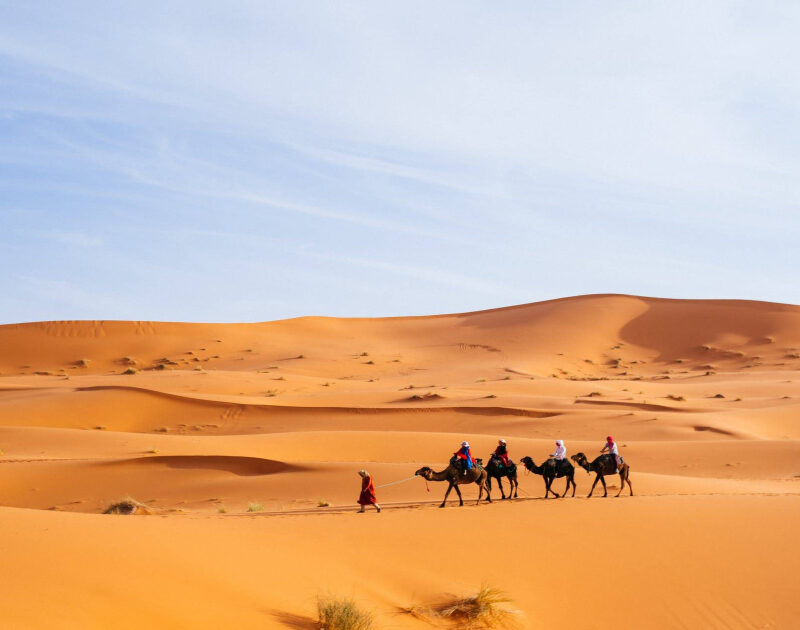 Persone che fanno trekking con i cammelli a Merzouga durante il tour di 6 giorni da Essaouira a Casablanca.