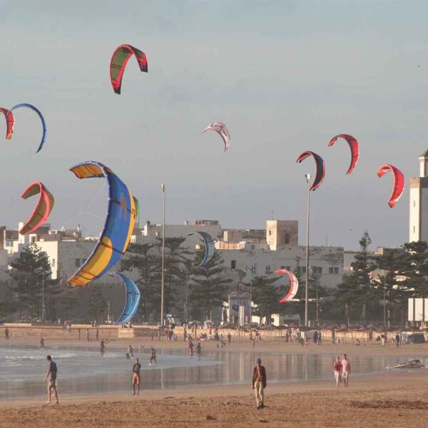 Kite surfisti sulla spiaggia di Essaouira durante un'escursione di un giorno da Marrakech.