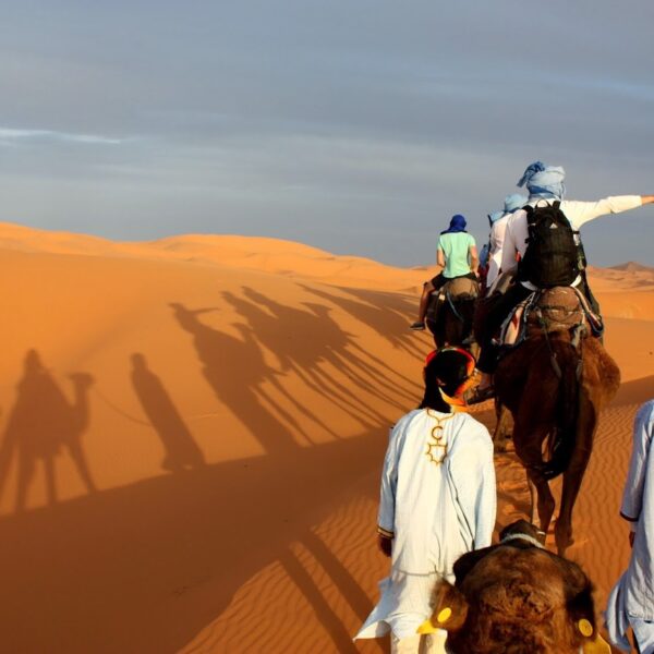 Gente haciendo senderismo en camello en Merzouga durante el viaje de 3 días de Agadir a Fez.