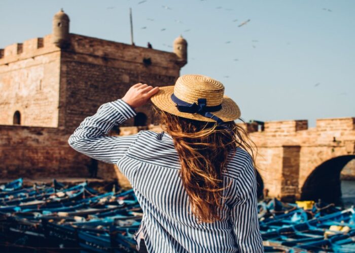 Una mujer con sombrero en el puerto durante la excursión de un día de Marrakech a Essaouira.