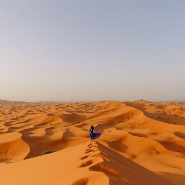 Una mujer camina por las dunas de Merzouga