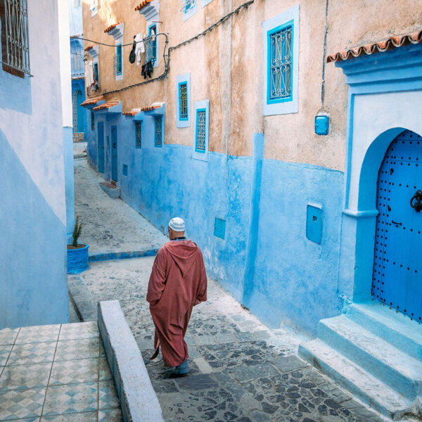 Un anziano passeggia per le strade blu di Chefchaouen durante il tour di 14 giorni in Marocco da Marrakech.